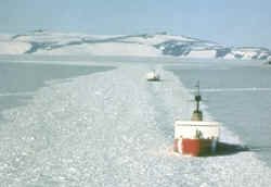 US icebreaker escorting a supply ships through an open channel filled with loose "brash" ice, phot use courtesy NSF