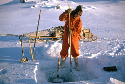 Barry Heywood chiseling a hole through freshwater lake ice